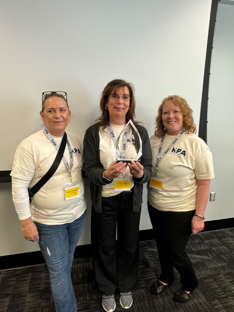 Three smiling women standing next to each other.